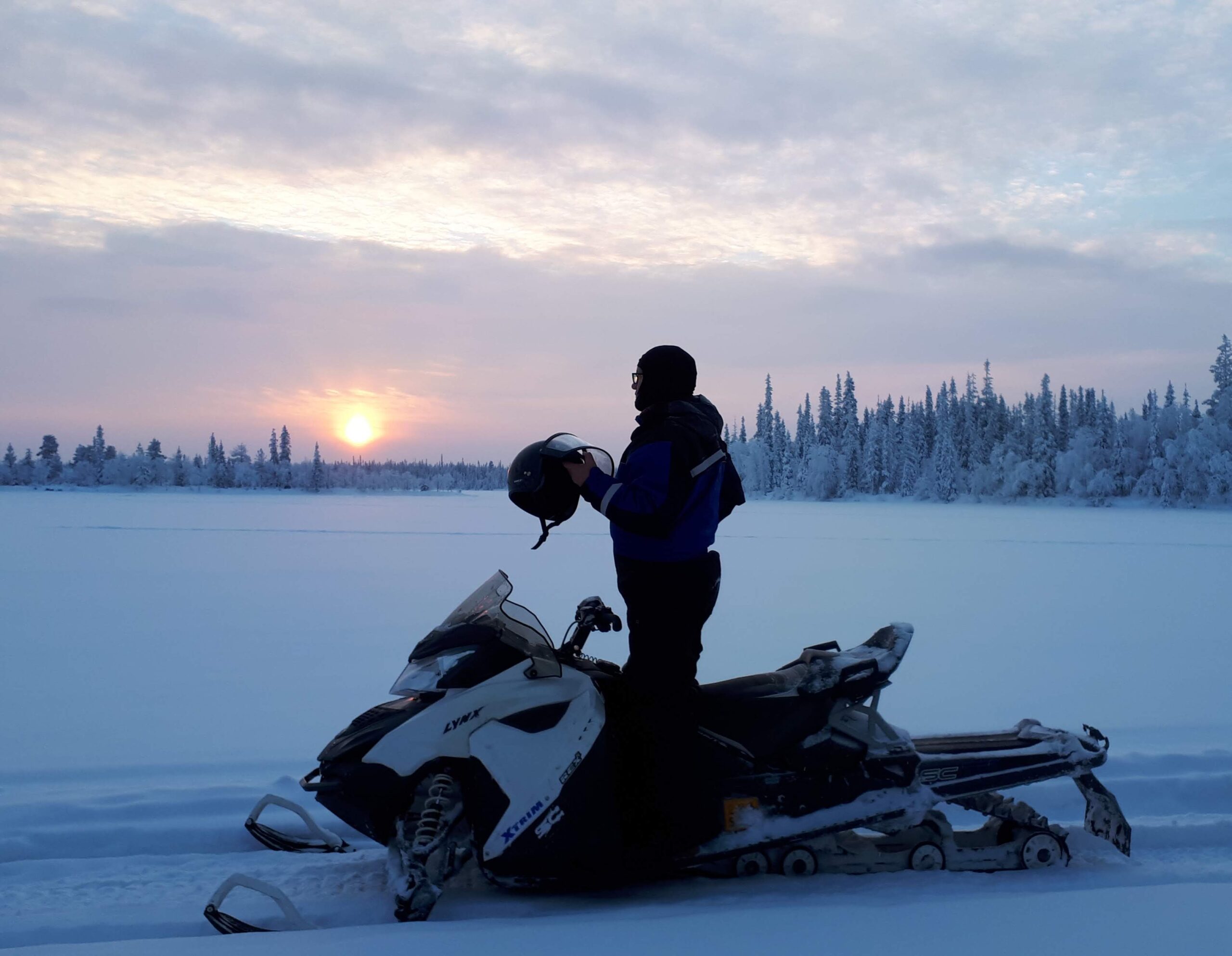 Snowmobiler and sunset